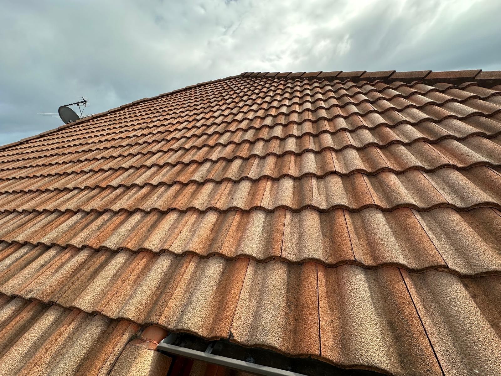 Concrete tile roof clean and restored after professional washing service.