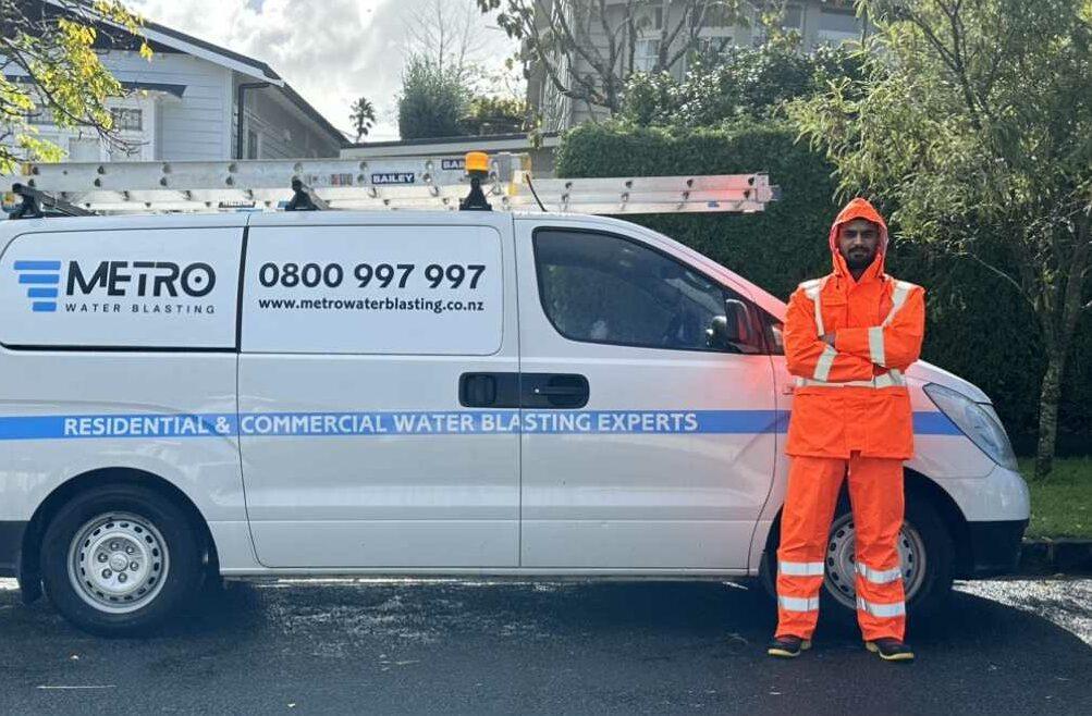 Metro Water Blasting technician performing house washing to clean the exterior of a residential property in Auckland.