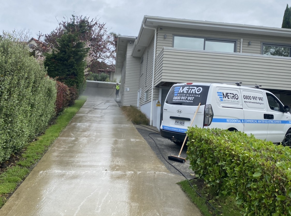 Gutter completely clogged with thick layers of wet leaves, sticks, and organic debris before cleaning.
