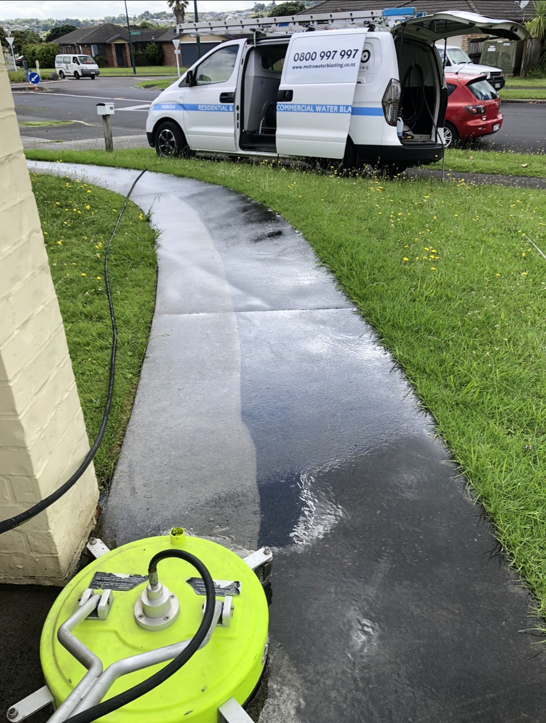 Concrete pathway restored to a clean, bright surface after professional water blasting service.