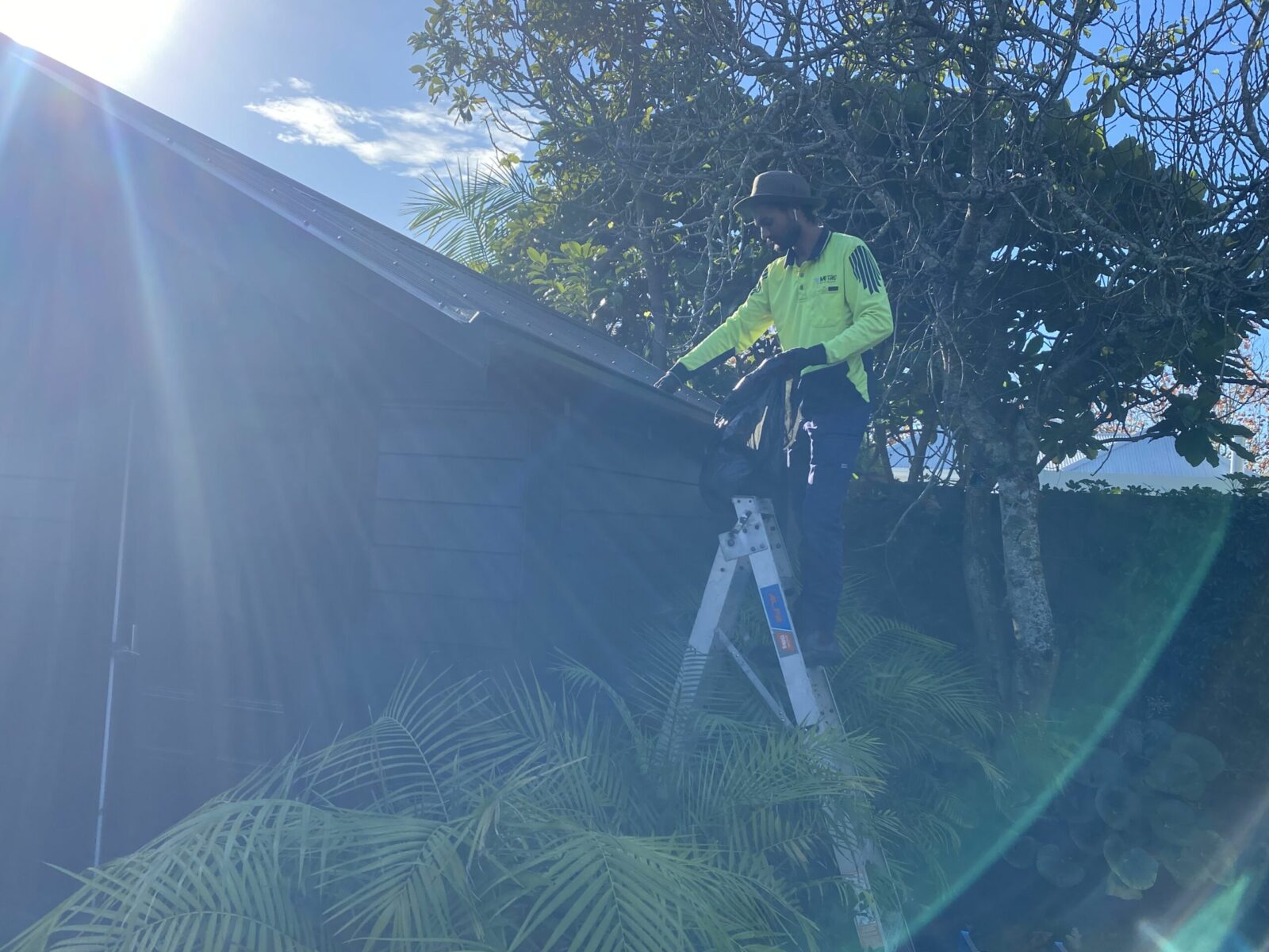Metro Water Blasting technician hand-cleaning gutters at a residential property in Ponsonby.