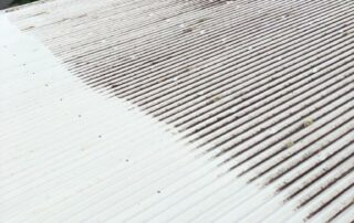 Metro Water Blasting technician washing a large commercial roof during professional cleaning service.
