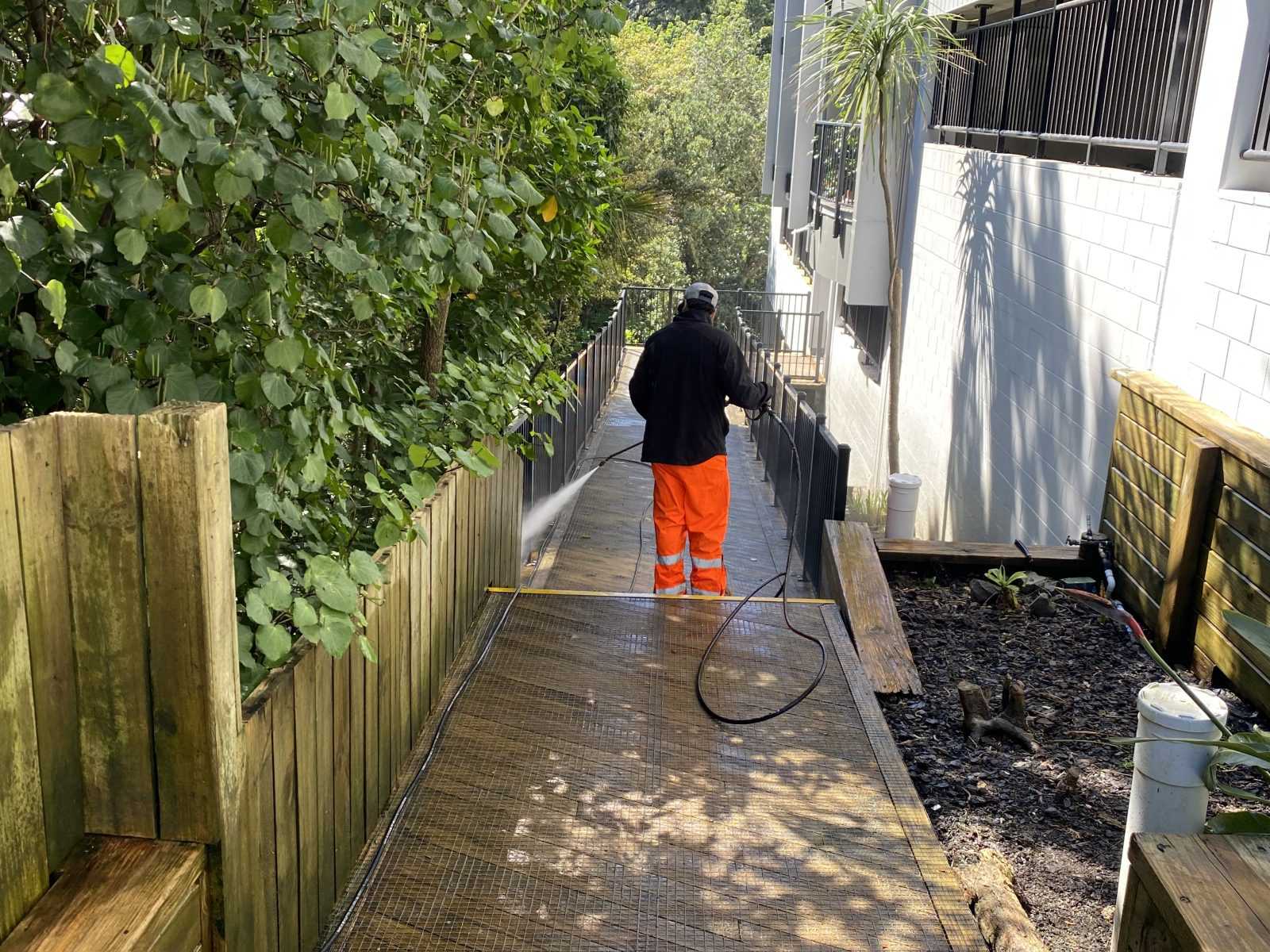 Commercial concrete surface being cleaned with high-pressure water blasting to remove dirt, grime, and stains.